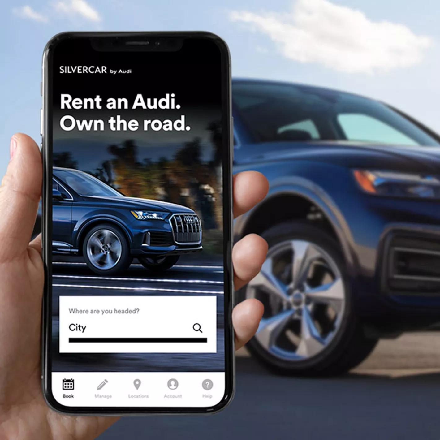 A phone showing the Silvercar by Audi app beside a blue Audi